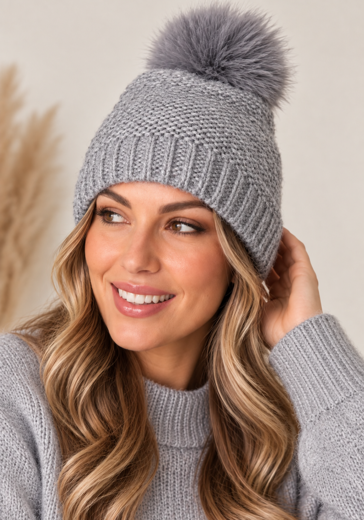 Grey pom pom beanie with sparkly knit texture and fluffy top for warm autumn winter style