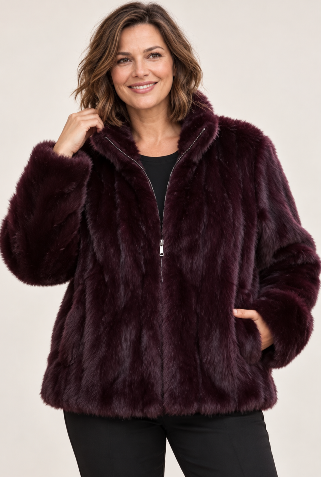Model wearing a berry faux fur zip-up coat with high collar, side pockets and relaxed fit
