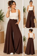 Model wearing chocolate belted palazzo trousers with wide leg and statement belt in a cream outfit