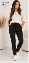 Black pull-on magic trousers with drawstring waist, slim fit and pockets on model